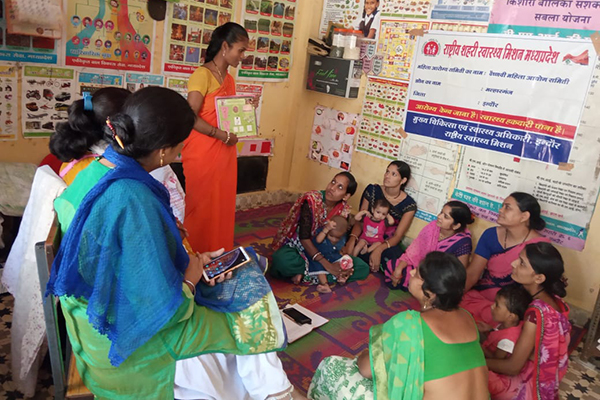 TCI Evaluation_1 Women sitting in a circle with one teacher standing and holding cards
