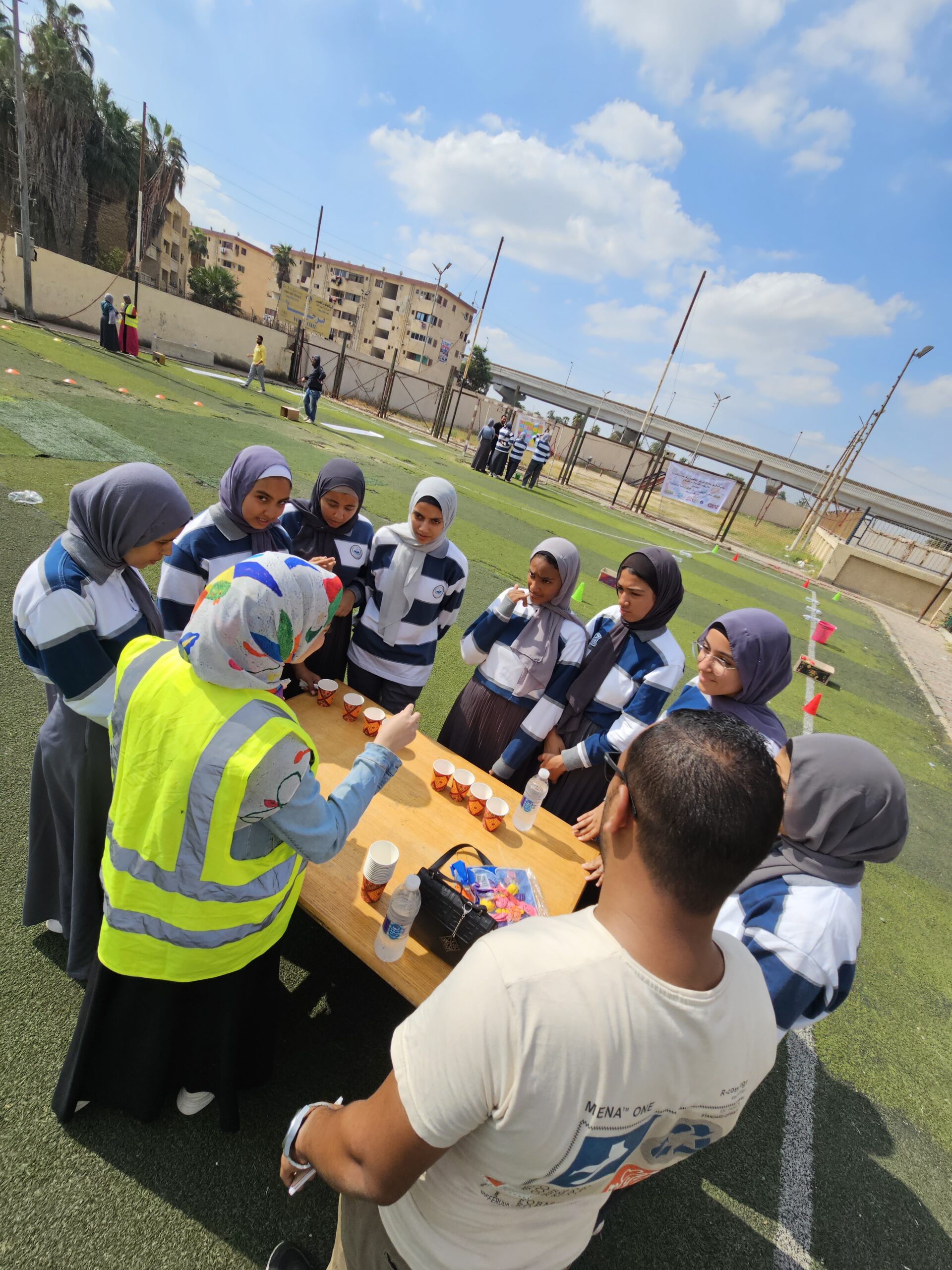 un groupe de jeunes rassemblés autour d'une table avec des petites tasses